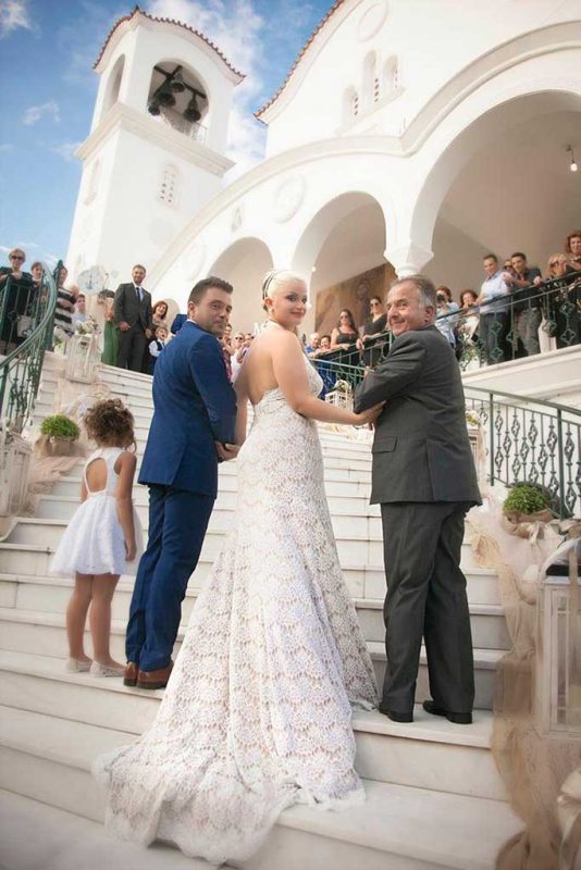 Νύφη στα σκαλιά της εκκλησίας με πατέρα και παρανυφάκι